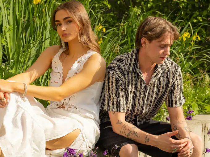 Mann og dame som sitter med grønne planter bak seg