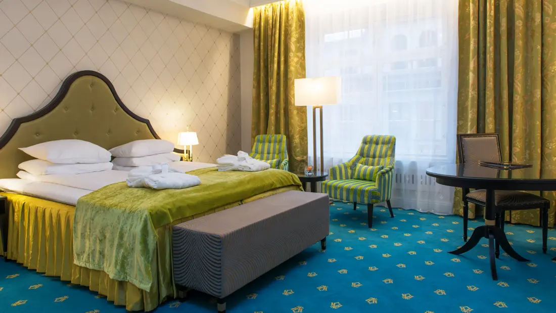 Dobbeltseng og to gode lenestoler på Hotel Bristol i Oslo sentrum