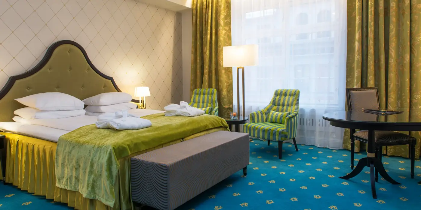 Dobbeltseng og to gode lenestoler på Hotel Bristol i Oslo sentrum