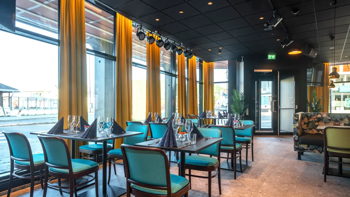 Vindu fra gulv til tak, spisebord, blå stoler