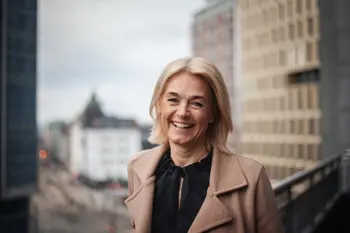 Portrettbilde av Kristin Nyquist. Hun smiler mot kamera, og i bakgrunnen ser vi Oslo Sentrum. 
