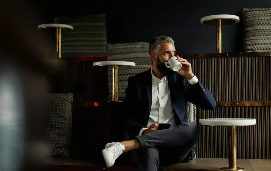 Forretningsmann drikker kaffe på kafé