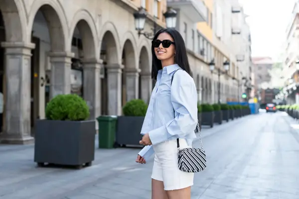Beautiful young woman standing on street in front of building