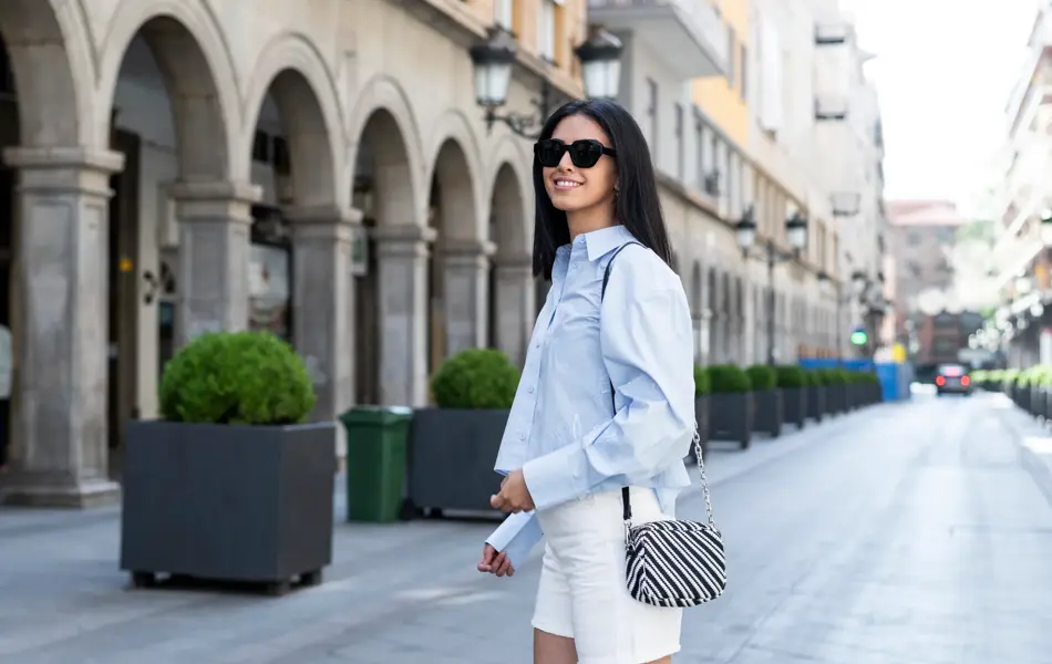 Beautiful young woman standing on street in front of building
