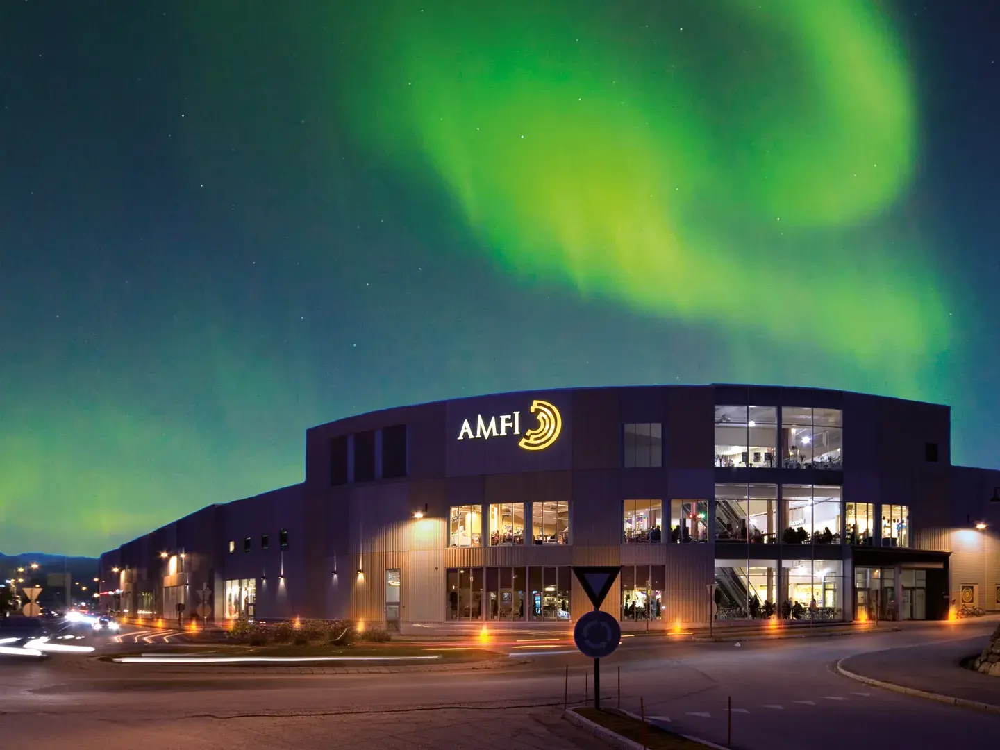 Fasadebilde med nordlys om natten av Amfi Finnsnes