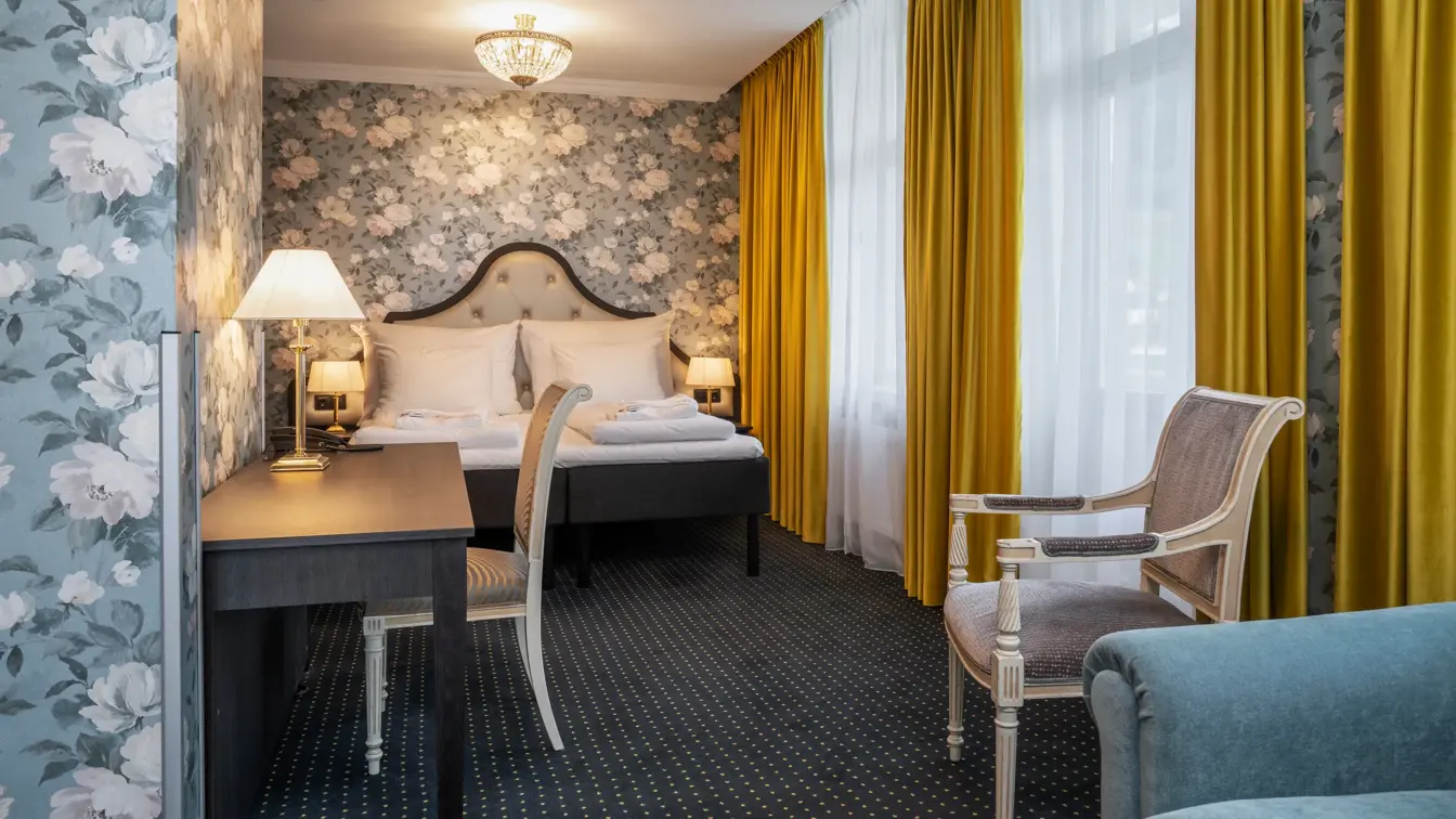 Skrivebord, gule gardiner, vindu, tapetvegg, dobbeltseng