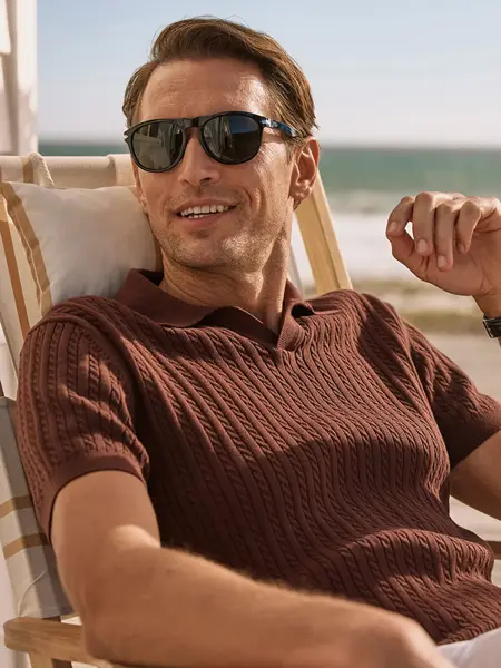 Mann med solbriller som sitter i en strandstol