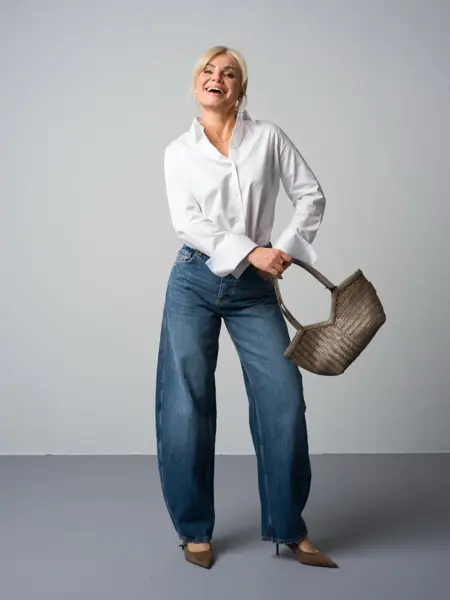 Marianne i hvit skjorte, jeans, pumps og veske