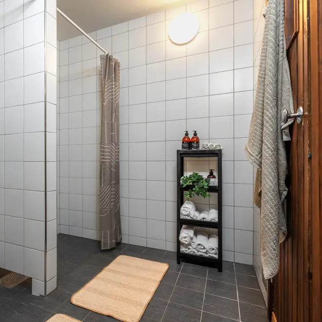 Felles dusj som hører til sauna, dusjforheng og håndklær.