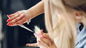 Frisør klipper blondt langt hår