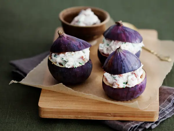 Tre lilla fiken fylt med ricotta på en trefjøl