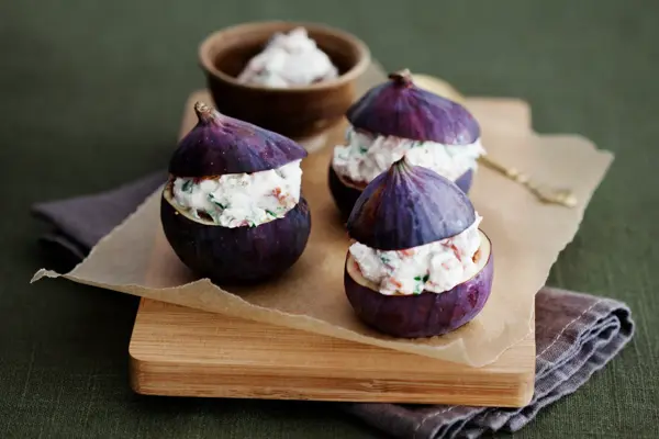 Tre lilla fiken fylt med ricotta på en trefjøl