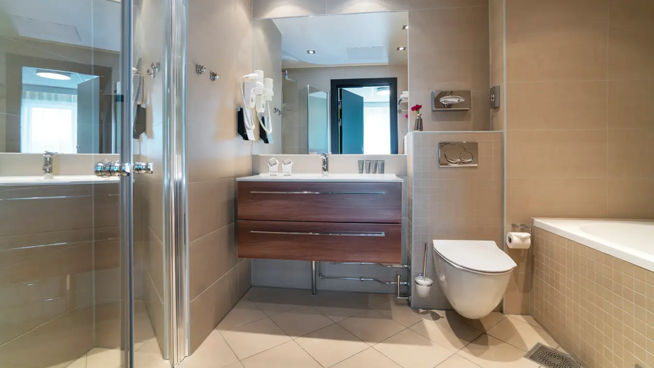 Bad på en av suitene med badekar, toalett, stor dusj og vask på Thon Hotel Europa i Oslo sentrum rett ved Slottsparken