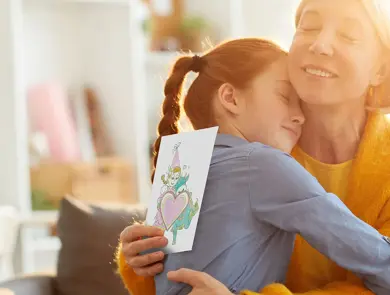 mor og datter som klemmer hverandre etter at datter har gitt amfelia og oskar-tegning