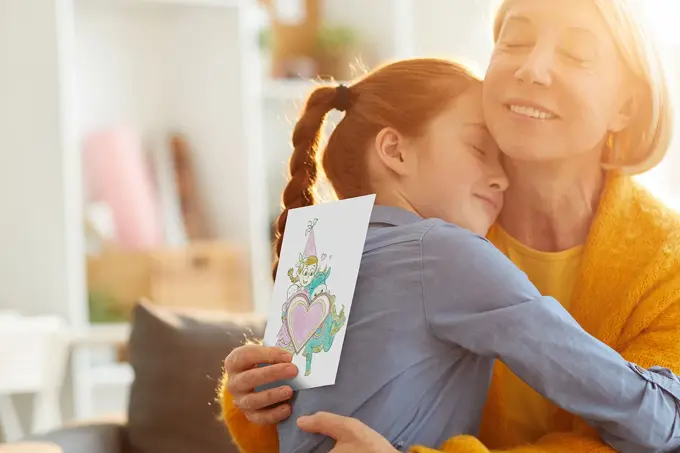 mor og datter som klemmer hverandre etter at datter har gitt amfelia og oskar-tegning
