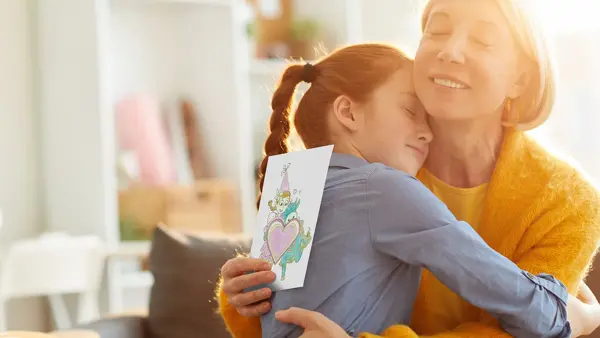 mor og datter som klemmer hverandre etter at datter har gitt amfelia og oskar-tegning