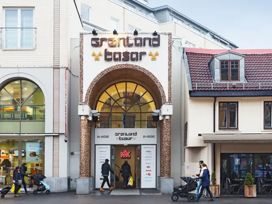 Fasadebilde av Grønland Basar viser kunder ved inngangen til senteret