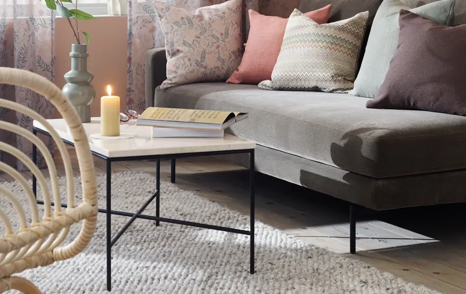 stue med grå sofa og lyse, blomstrende gardiner