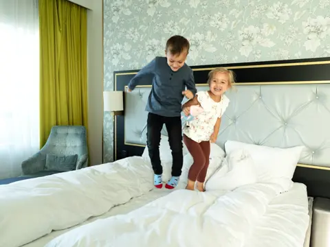 Barn hopper i hotellseng