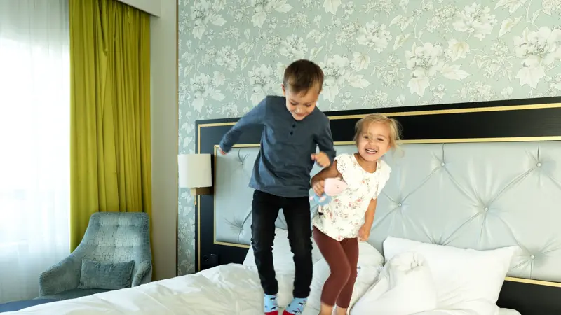 Barn hopper i hotellseng
