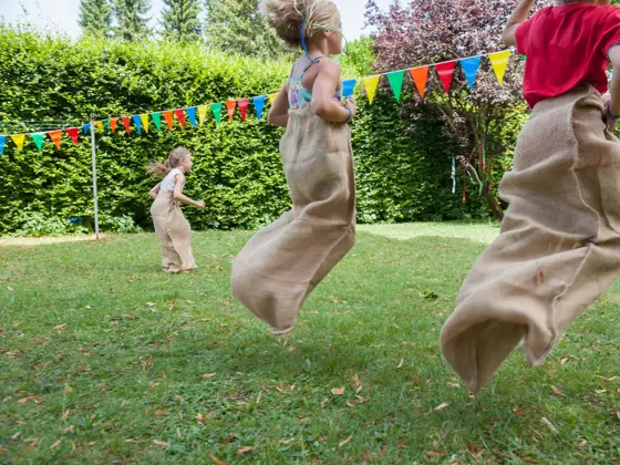 Children having a sack race in garden on a birthday party