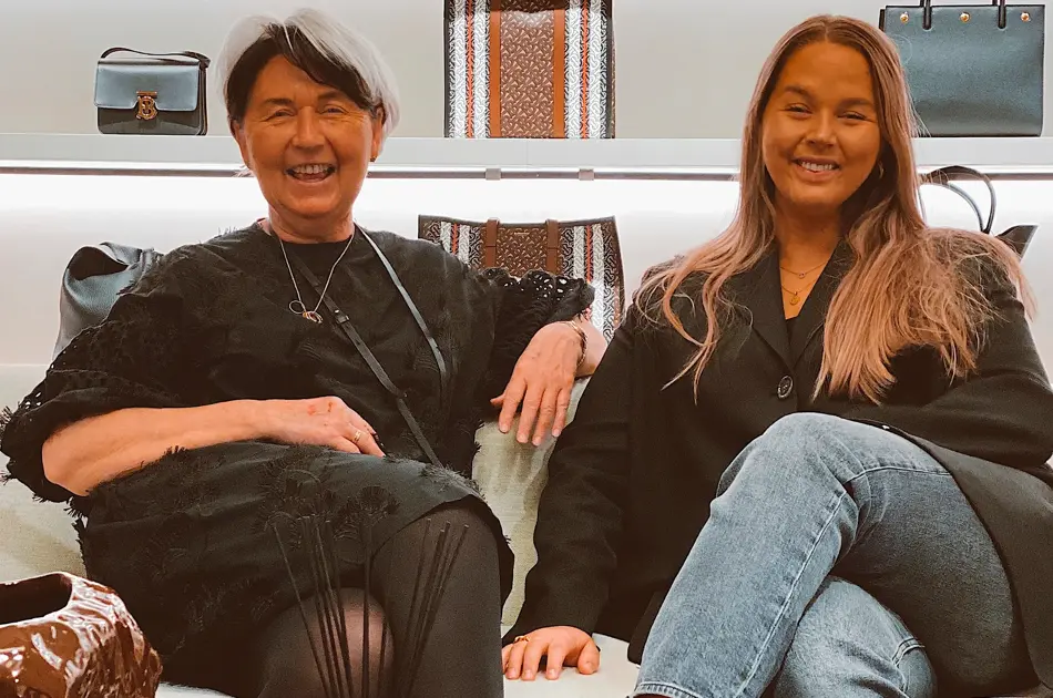 Mor og datter som sitter sammen og smiler