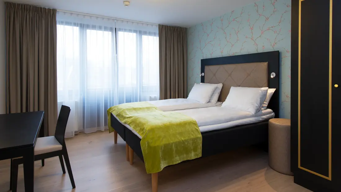 Dobbeltseng og pult på juniorsuite på Thon Hotel Slottsparken i Oslo sentrum rett ved Karl Johan