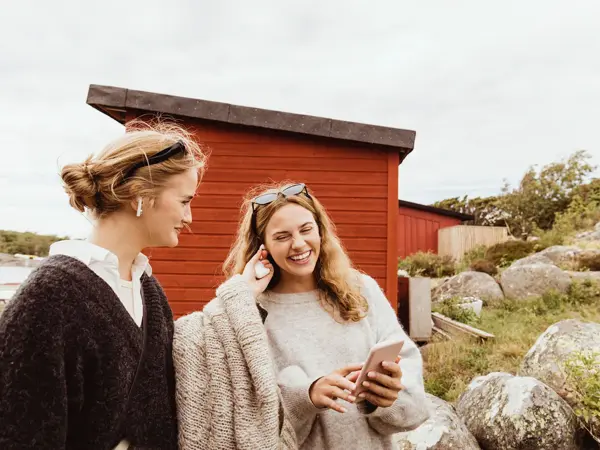 To venninner smiler og koser seg på sommerhytte 