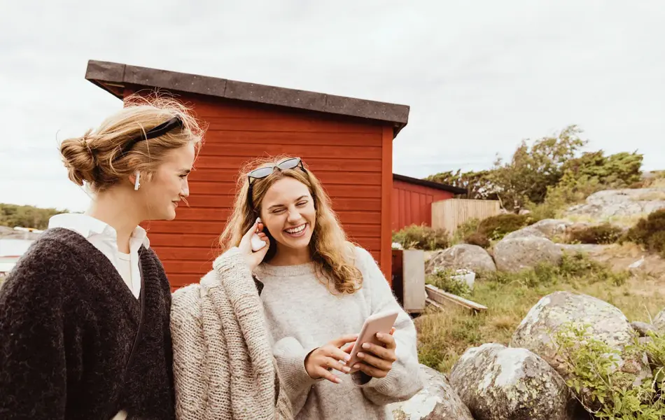 To venninner smiler og koser seg på sommerhytte 