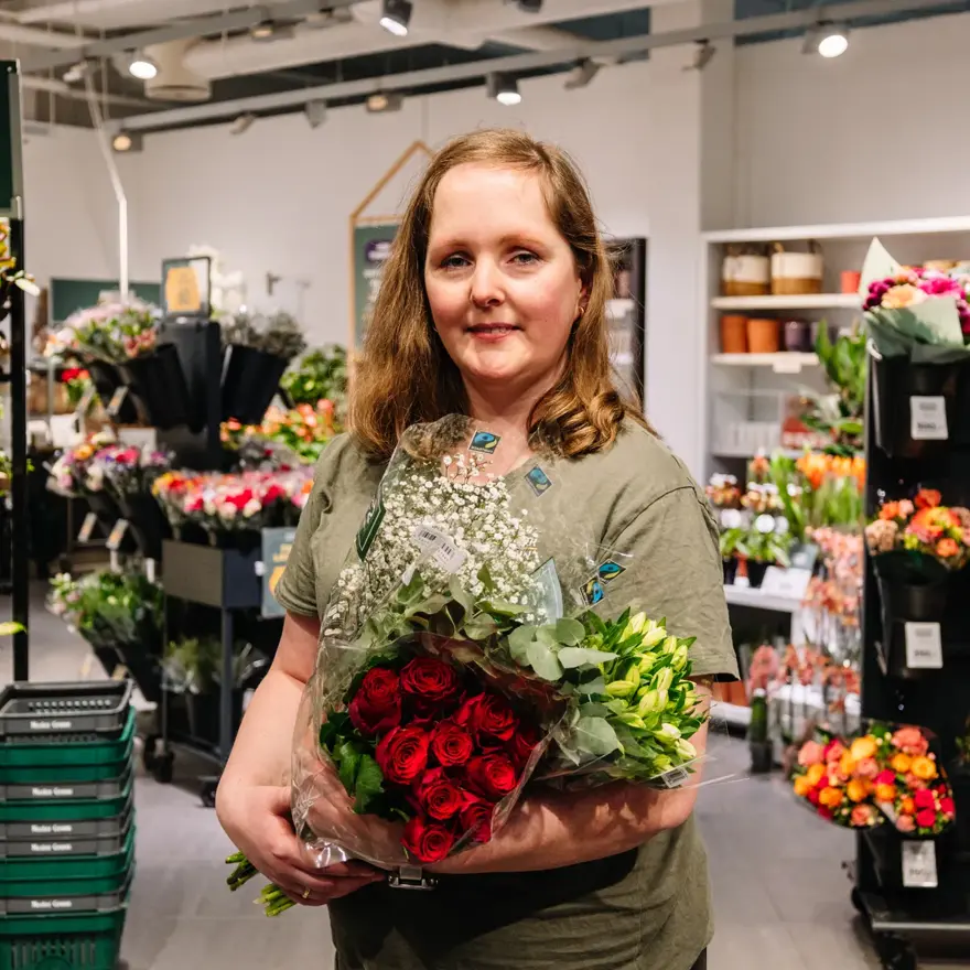 dame holder buketter med blomster