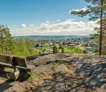Bilde av en benk på et fjell, med utsikt over Strømmen