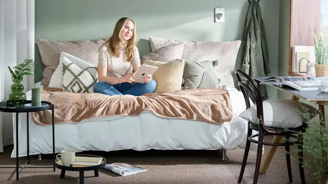 Studentpike i sengen dekorert med puter og småmøbler rundt