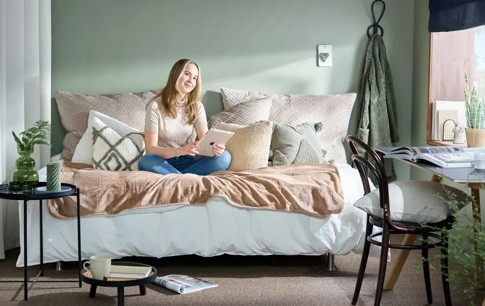 Studentpike i sengen dekorert med puter og småmøbler rundt