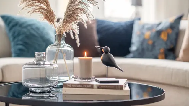 Blå puter og stilleben med fjærdekorasjon