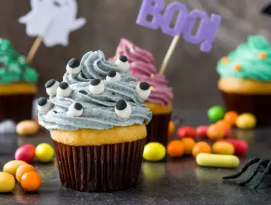 Halloween cupcakes and cobweb on rustic wooden background