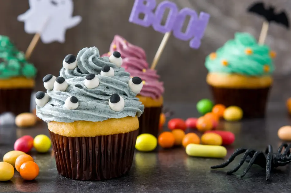 Halloween cupcakes and cobweb on rustic wooden background