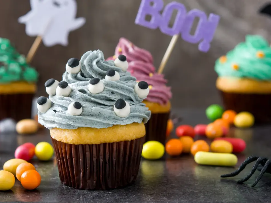 Halloween cupcakes and cobweb on rustic wooden background