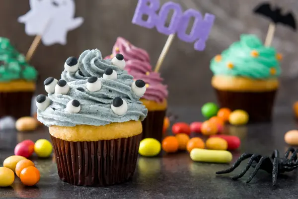 Halloween cupcakes and cobweb on rustic wooden background