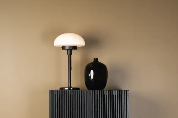 Lampe og en vase på en kommode