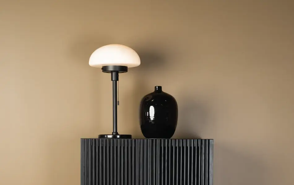 Lampe og en vase på en kommode
