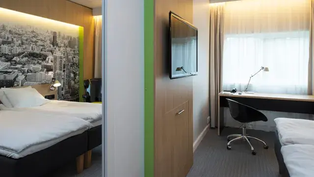 Seng, skrivebord og TV i twin rom på Thon Hotel Bergen Airport
