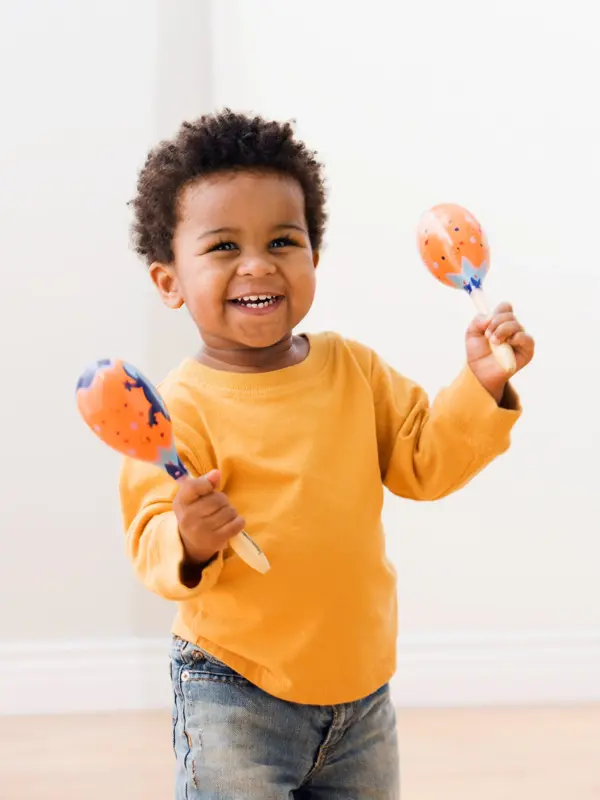 blid gutt med maracas som smiler