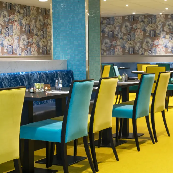 Frokostsal med gule og turkise stoler på Thon Hotel Terminus i Oslo sentrum nær jernbanetorget