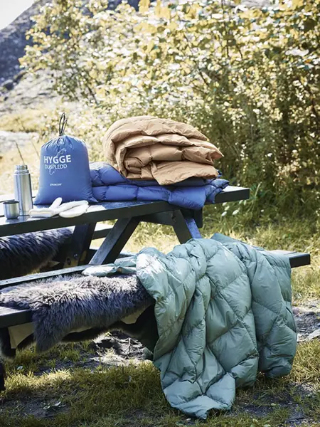 Tildekket benk med dyner og pledd