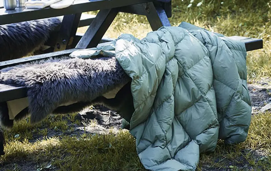 Tildekket benk med dyner og pledd