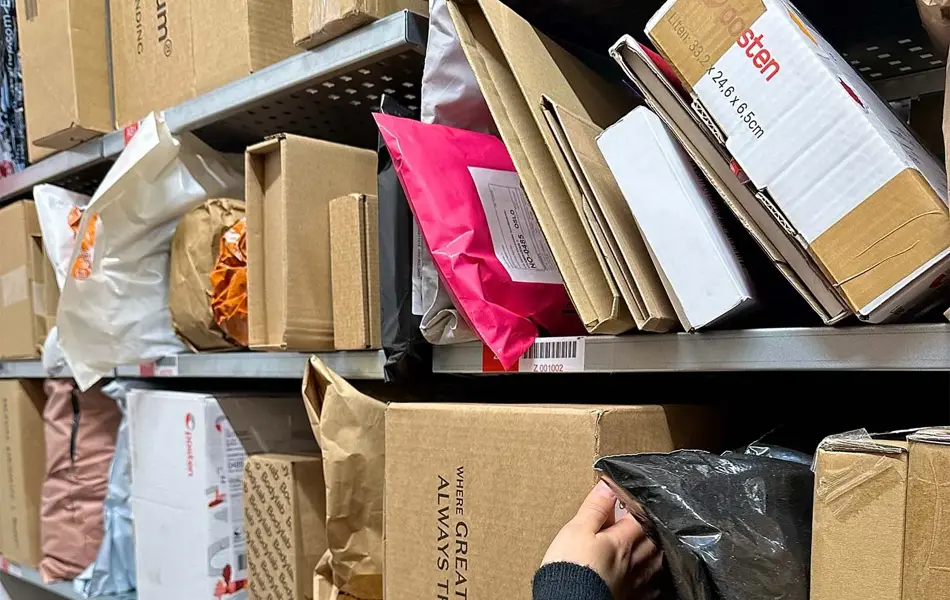 Noen som sorterer pakker i hyller