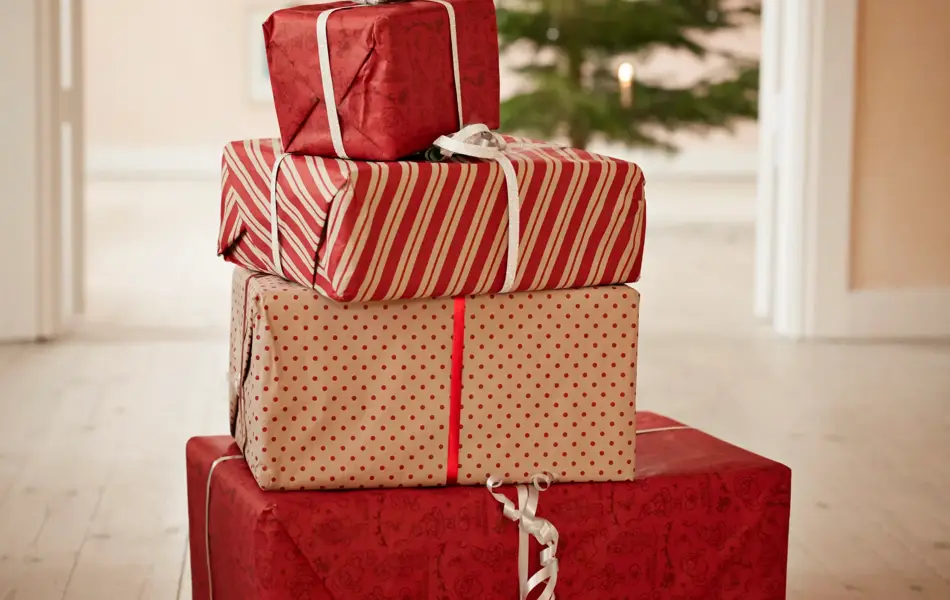 Still-life of stack of christmas presents, tree in background