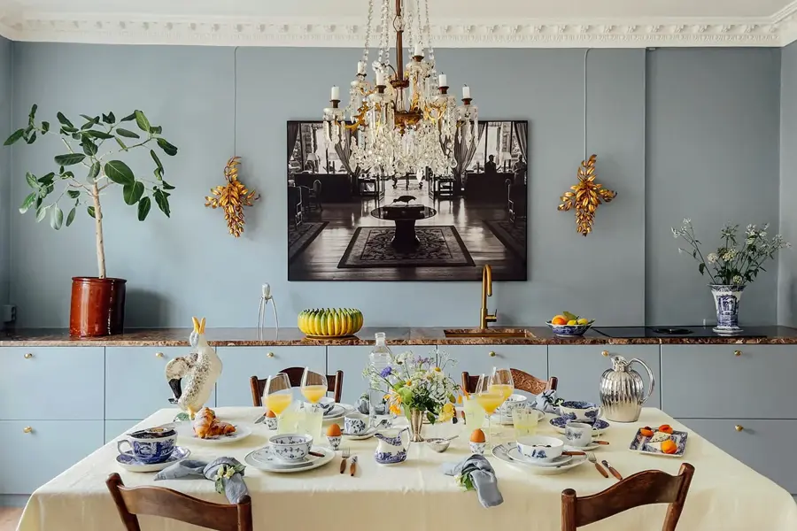 Bord tildekket og lampe over. En skjenk dekorert i bakgrunn med bilde på veggen