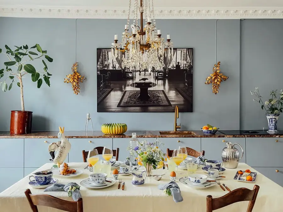 Bord tildekket og lampe over. En skjenk dekorert i bakgrunn med bilde på veggen