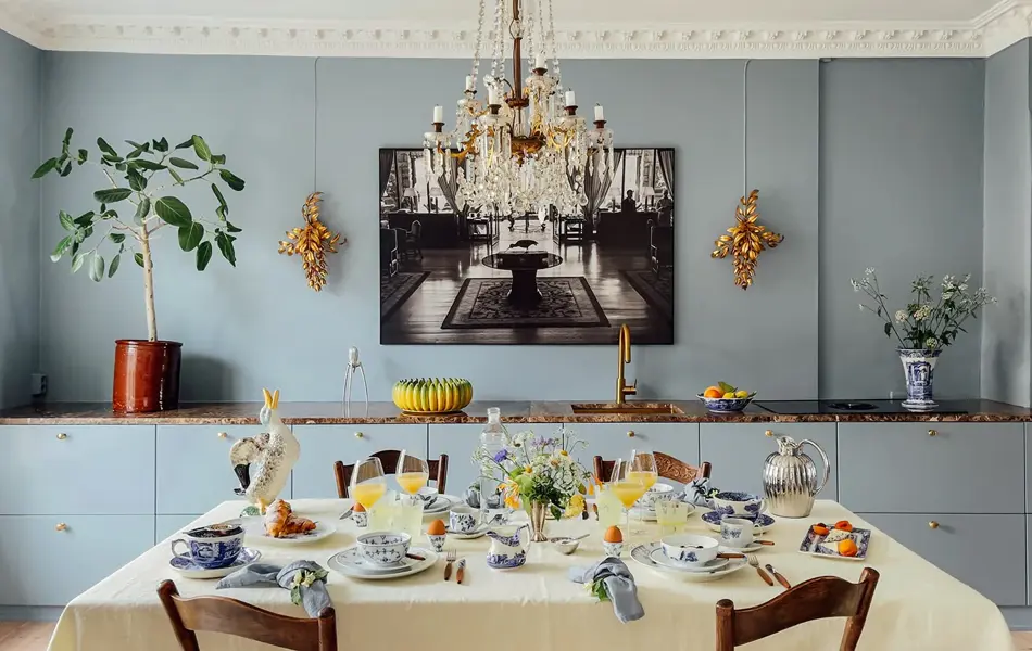 Bord tildekket og lampe over. En skjenk dekorert i bakgrunn med bilde på veggen